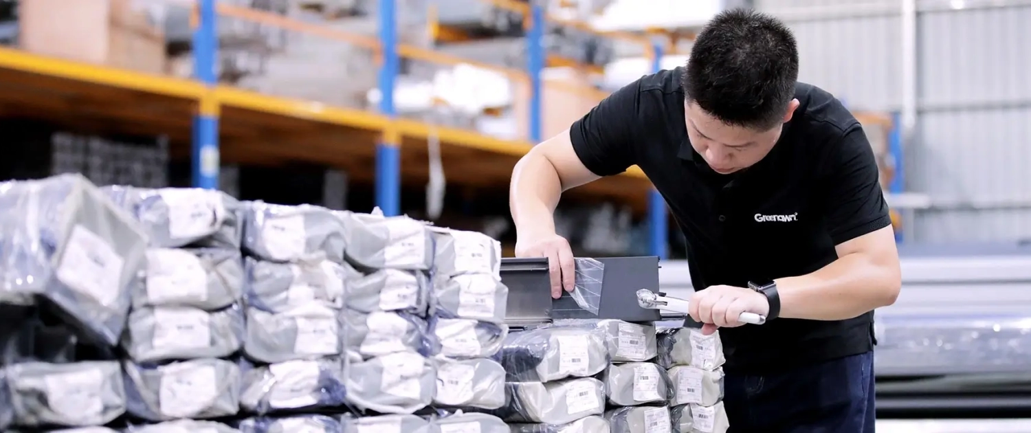 Worker visually inspecting packaged goods in warehouse quality control process