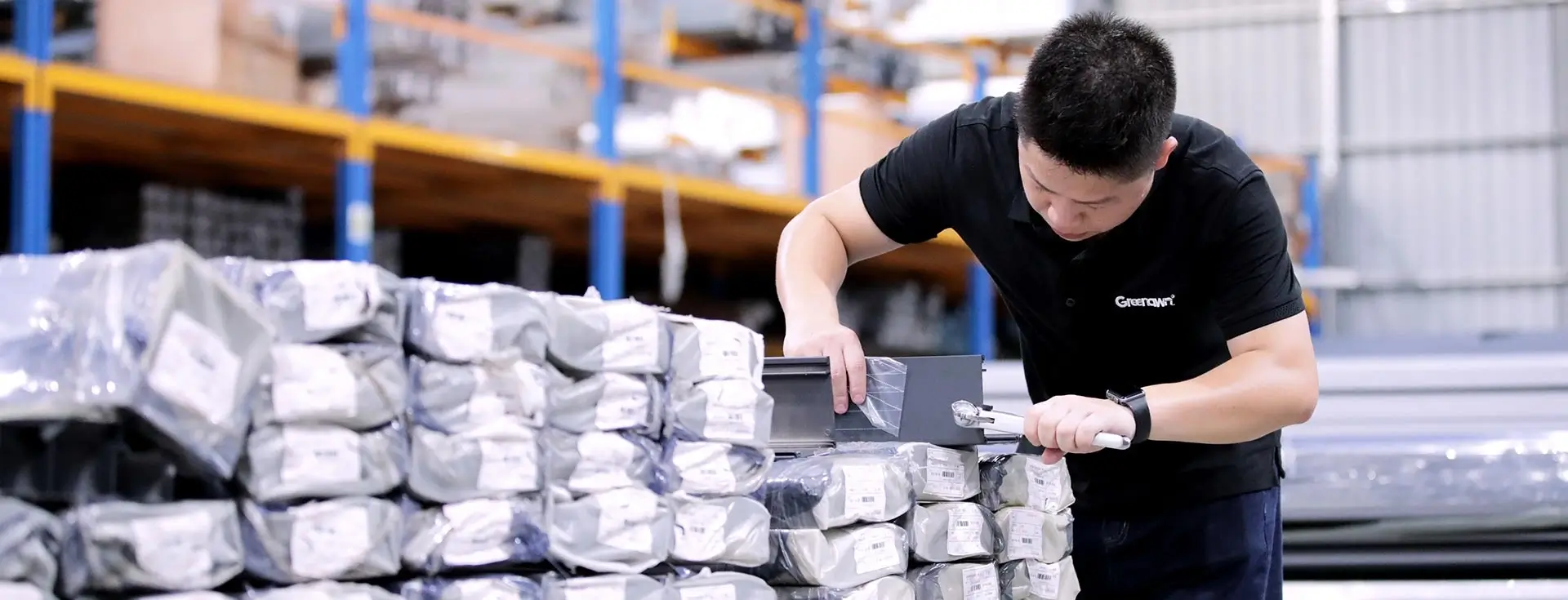 Worker visually inspecting packaged goods in warehouse quality control process