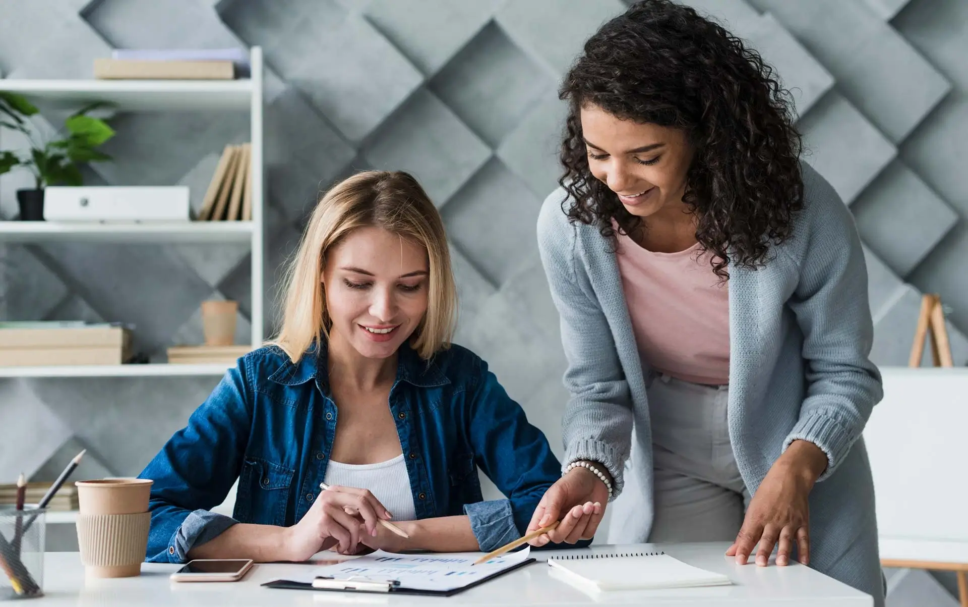 Two female designers discussing technical drawings as part of collaborative design support